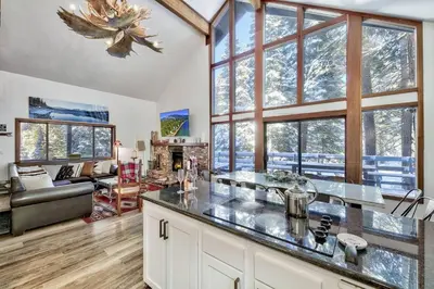 a kitchen and living room with large windows at Cozy Cabin&HotTub Mins to N StarSki Sleeps 12 in Tahoe Vista