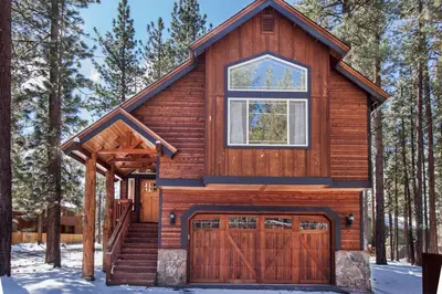 a log house with a garage in the snow at Luxury Home Near Lake, Heavenly, Casinos in South Lake Tahoe