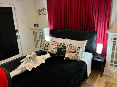 a bedroom with a black bed with a red curtain at Reno MidTown Movie House in Reno