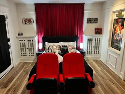 a bedroom with two red chairs and a bed at Reno MidTown Movie House in Reno