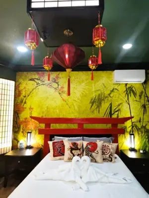 a bedroom with a large bed with a yellow wall at Asian Zen Den in Sparks