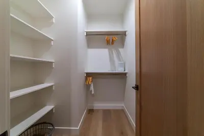 a walk in closet with white walls and white shelves at Spectacular New 4BR Townhome: Garage, Jacuzzi, BBQ in Mammoth Lakes