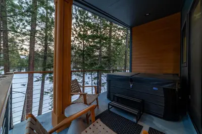 a screened in porch with a view of the woods at Spectacular New 4BR Townhome: Garage, Jacuzzi, BBQ in Mammoth Lakes