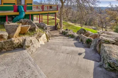 a playground with a slide and some rocks at Yosemite Gateway Sleeps 18 - Coarsegold Villa near Bass Lake in Coarsegold