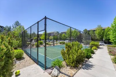 a tennis fence with a tennis court in a garden at New Luxurious 1BR Apartment Heated Pool Spa & Sauna in Reno
