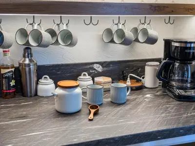 a kitchen counter with cups and utensils on a wall at Mountain Retreat near Skiing, HotTub, PetFriendly in Tahoe City