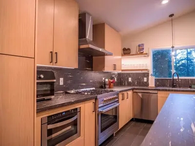 a kitchen with wooden cabinets and a stove top oven at Mountain Retreat near Skiing, HotTub, PetFriendly in Tahoe City