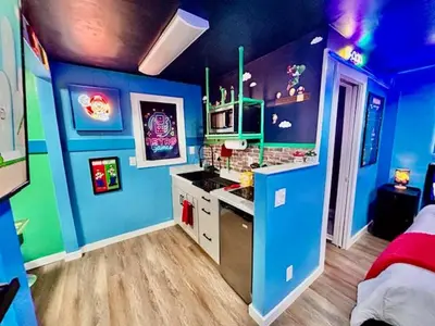 a room with blue walls and a kitchen with a stove at GameZone in Sparks