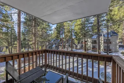 a balcony with a table and chairs and trees at Alpine Retreat in the Heart of Incline Village condo in Incline Village