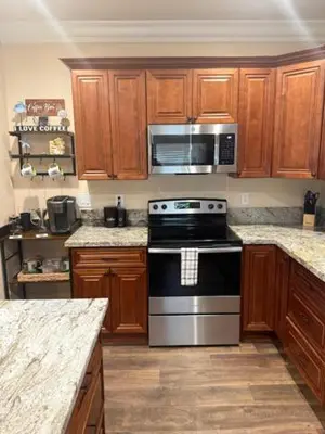 a kitchen with wooden cabinets and a stove top oven at Beach House Staycation in Sparks