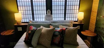 a bedroom with a bed with pillows and two lamps at MidTown Zen Den in Reno