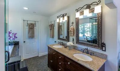 a bathroom with two sinks and two mirrors at Luxurious Yosemite Pines Lodge, Pool, Spa, Ponies, Views in Mariposa