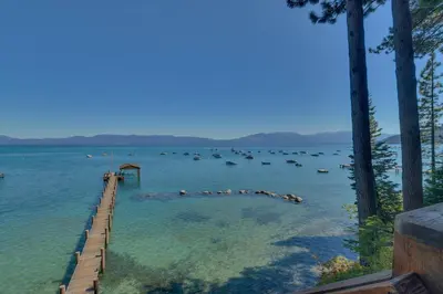 a large body of water with a dock in it at Rubicon Bay Lakefront by Tahoe Getaways - 4BR with Bonus Room, Private Pier, Buoy & Beach Access in Tahoma
