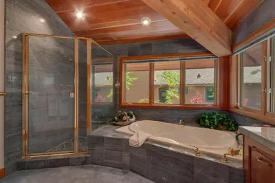 a bathroom with a tub and a glass shower at Rubicon Bay Lakefront by Tahoe Getaways - 4BR with Bonus Room, Private Pier, Buoy & Beach Access in Tahoma
