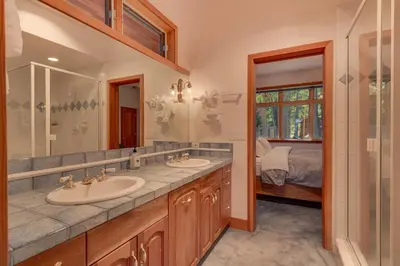 a bathroom with two sinks and a large mirror at Rubicon Bay Lakefront by Tahoe Getaways - 4BR with Bonus Room, Private Pier, Buoy & Beach Access in Tahoma