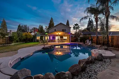 a swimming pool in a backyard with a house at Huge House-Yard-Pool Hot Tub in Citrus Heights