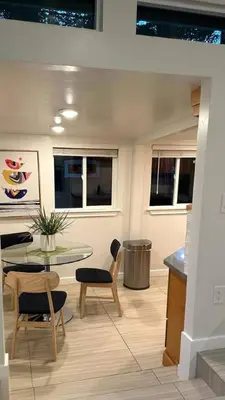 a living room with a glass table and chairs and a table and chairsktop at King Bed-Peaceful Modern Cottage-Garden Setting in Carmichael