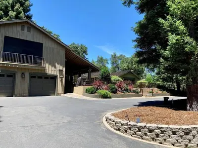 a driveway leading to a house with a garage at King Bed-Peaceful Modern Cottage-Garden Setting in Carmichael