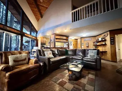 a living room with leather couches and a cat sitting on a rug at One The First Fairway - Walk to the Lake in Incline Village