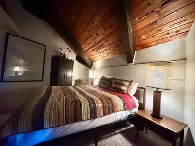 a bedroom with a bed and a lamp on a table at One The First Fairway - Walk to the Lake in Incline Village