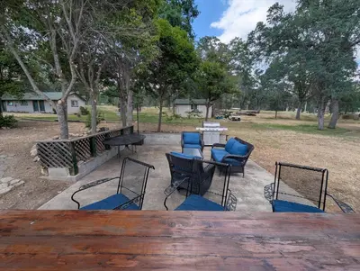 a patio with a table and chairs and trees at Squaw Valley Motel Room 7 in Dunlap