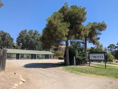 a motel sign and a tree in front of a building at Squaw Valley Motel Room 7 in Dunlap