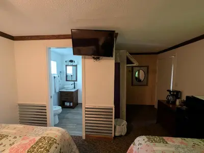 a hotel room with a bedroom with a television on a wall at Squaw Valley Motel Room 7 in Dunlap