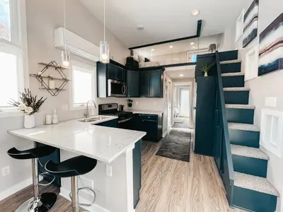 a kitchen with a counter and a staircase in a tiny house at Beautiful and Elegant River Front Cottage in Reno