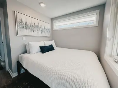 a small bedroom with a white bed and a window at Beautiful and Elegant River Front Cottage in Reno