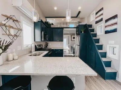a kitchen with a counter top and a staircase at Beautiful and Elegant River Front Cottage in Reno