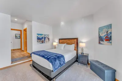 a bedroom with a large bed with a blue end table at Luxury Truckee Retreat with Hot Tub and Sauna in Truckee