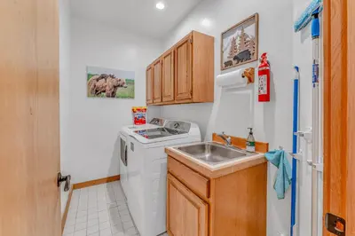 a small kitchen with a washing machine and a sink at Luxury Truckee Retreat with Hot Tub and Sauna in Truckee