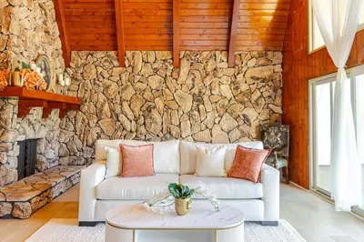 a living room with a couch and a stone wall at The Grand Waterside Estate Easy drive to Yosemite in Modesto