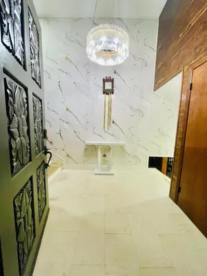 a hallway with a white marble wall with a chandelier at The Grand Waterside Estate Easy drive to Yosemite in Modesto