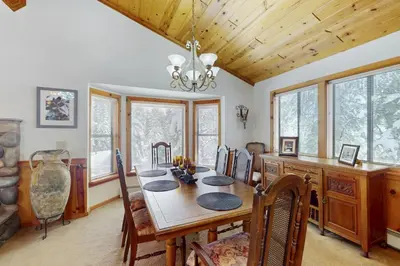 a dining room with a table and some windows at North Shore Escape in Carnelian Bay