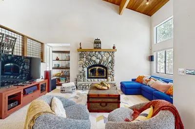a living room with a blue couch and a fireplace at Northstar Paradise in Ponderosa Fairway Estates
