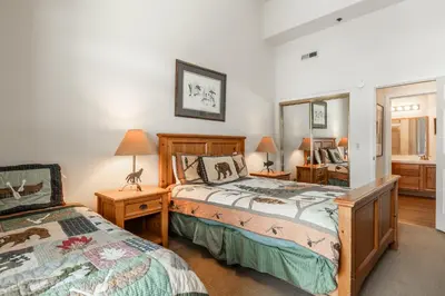 a bedroom with two beds and a mirror at Silverbear #41 - 2 Bedrm + Loft / 3 Bathrm 1/2 block to Canyon Lodge! Slps 8 in Mammoth Lakes