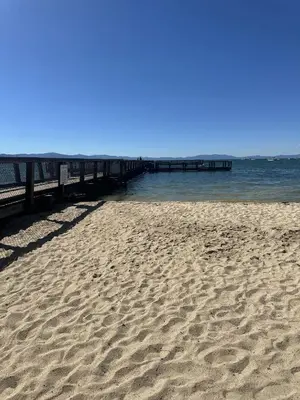 a sandy beach with a pier in the water at LLC1236 - Lakeside Landing condo in South Lake Tahoe