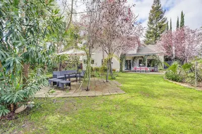 a yard with two picnic tables and a house at Rudraksha-Luxurious 5 BR House, Prime Location, Shopping, Dining, Medical, Education, Tourist Attractions in Fresno