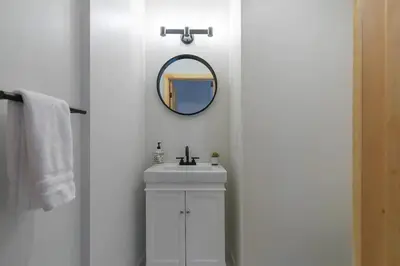 a white bathroom with a sink and a mirror at Updated Cabin near Beach&Ski HotTub Sauna Pets EV in Tahoe City