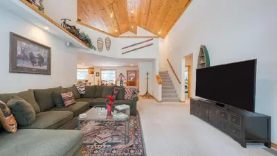 a living room with a couch and a flat screen tv at Pinewood Lodge by AvantStay Cozy Cabin Near Ski Resorts Hiking in Truckee
