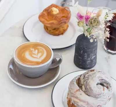 a cup of coffee and pastries on a table at New Upscale 1BR Stay with Mini Golf Sauna & Heated Pool in Reno