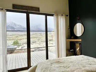 a bedroom with a large window with a view of the mountains at Luxury Design Rental with Breathtaking Mountain Views in Lone Pine, California in Lone Pine