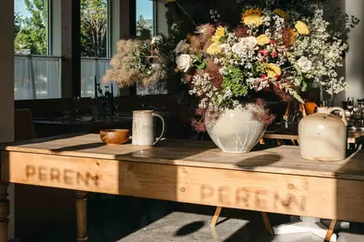 a wooden table with a vase of flowers on it at New Trendy 1BR Apartment with Heated Pool Gym & Minigolf in Reno