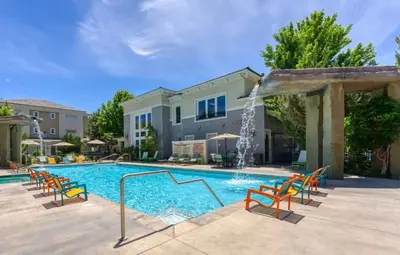 a swimming pool with chairs and a water fountain at New Cozy 1BR Apt with Gym Sauna & Heated Pool Access in Reno