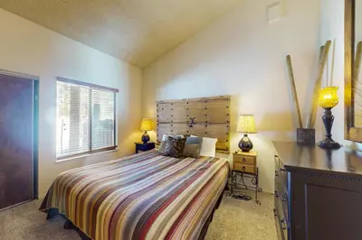 a bedroom with a bed and a desk and two lamps at Summit 295 in Mammoth Lakes