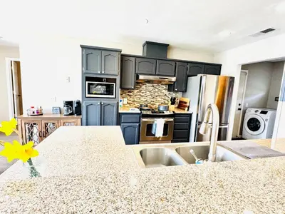 a kitchen with black cabinets and a counter top at Home at Yosemite Oakhurst in Oakhurst