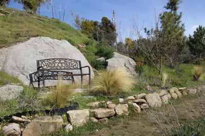a bench sitting on a hill next to a rock at Home at Yosemite Oakhurst in Oakhurst