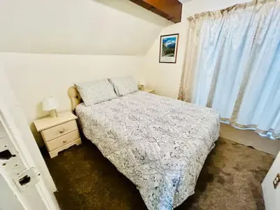 a bedroom with a bed and a nightstand and a window at Home in Yosemite-Brookside Cottage-Sleeps 10 in Yosemite West