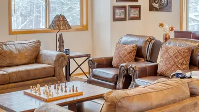 a living room with leather furniture and a chessboard on a table at Oslo Haus by AvantStay Cabin Retreat Near Northstar Downtown Truckee in Truckee